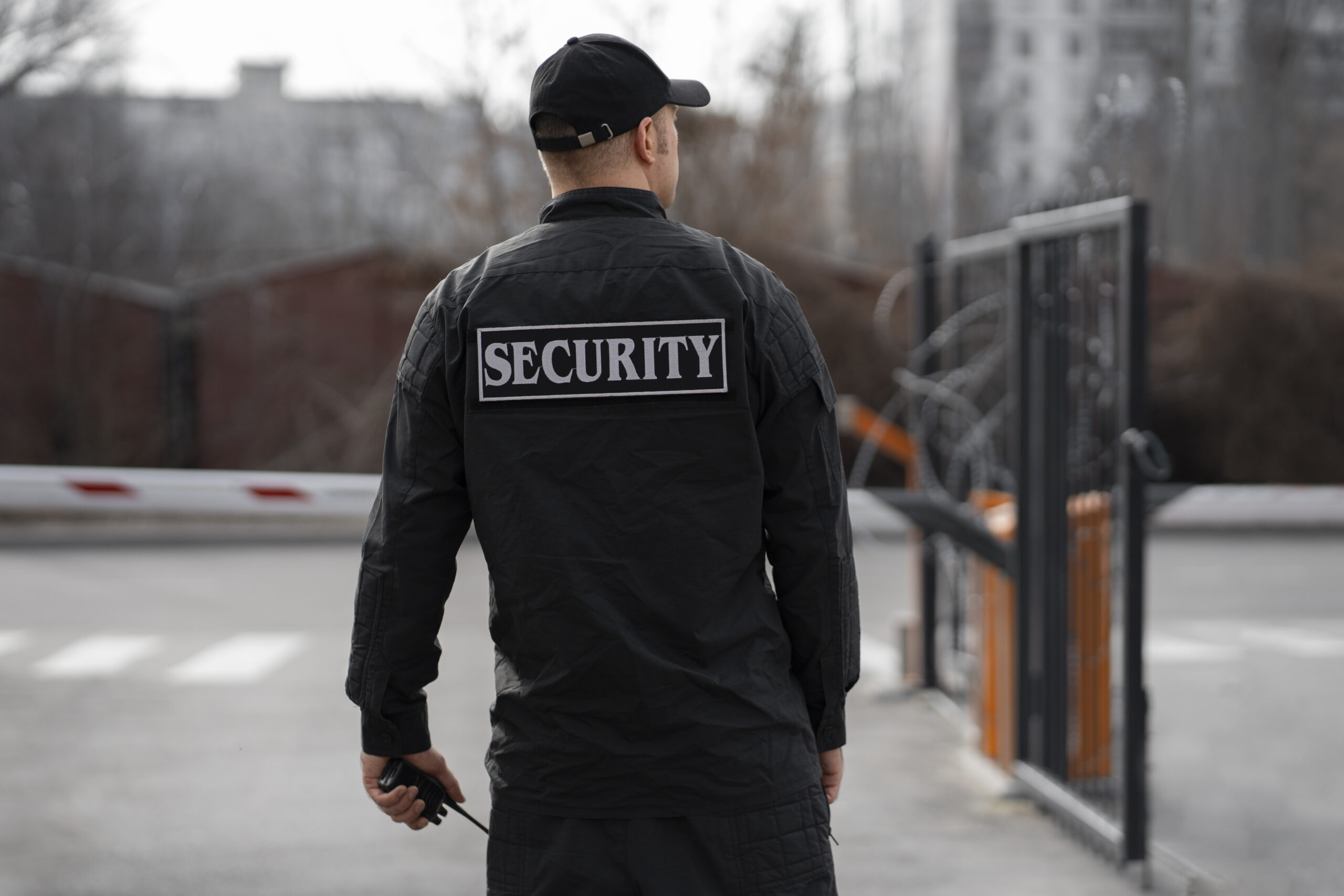 portrait male security guard with barbed wire fence scaled
