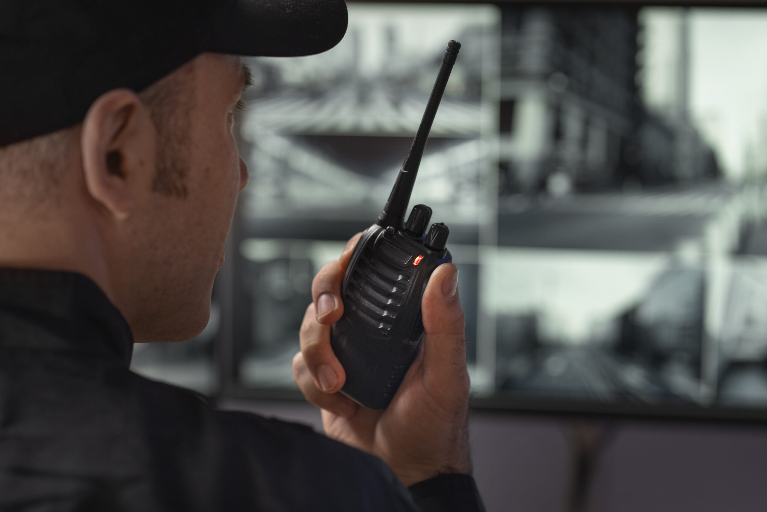 portrait male security guard with radio station camera screens scaled